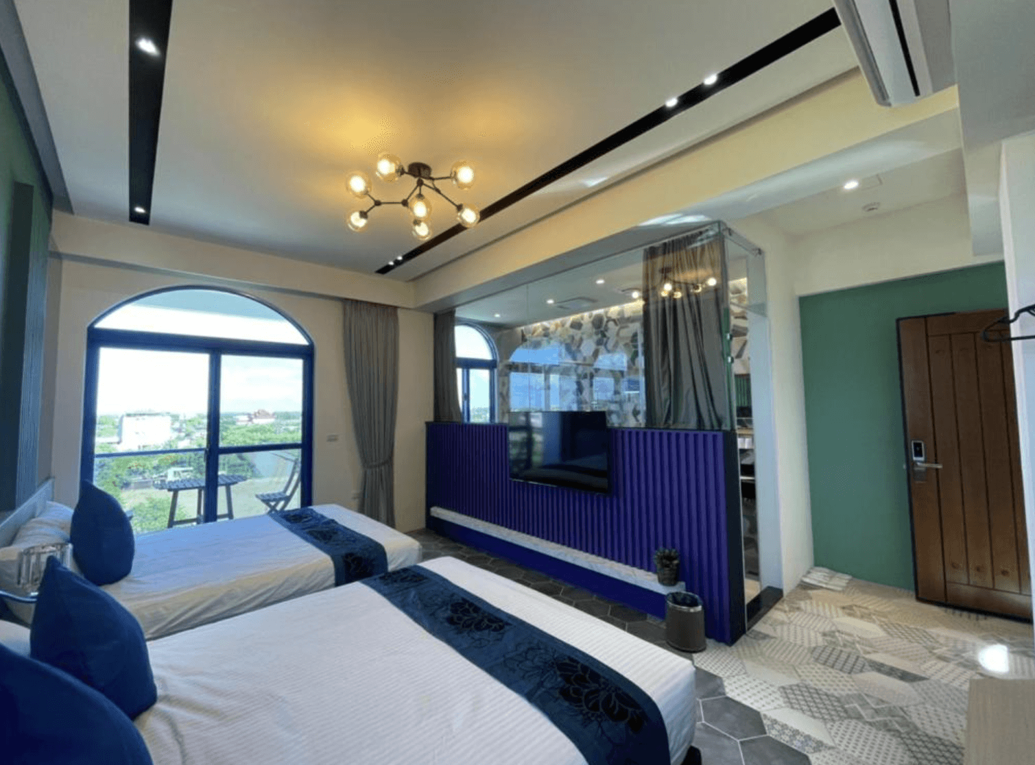 【吉安住宿】花蓮波西米亞電梯民宿 現代雙床房 — 以藍色元素與木質地板為主，房內配有兩張雙人床、大型電視及觀景窗戶，採光充足。