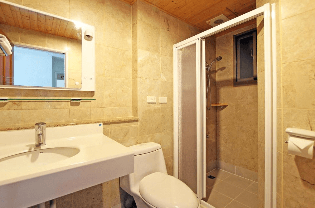 【墾丁寵物友善住宿】華納小筑浴室 — 採用米色石紋牆面與木質天花板設計，配置洗手台、馬桶與獨立淋浴間，空間乾淨簡潔。