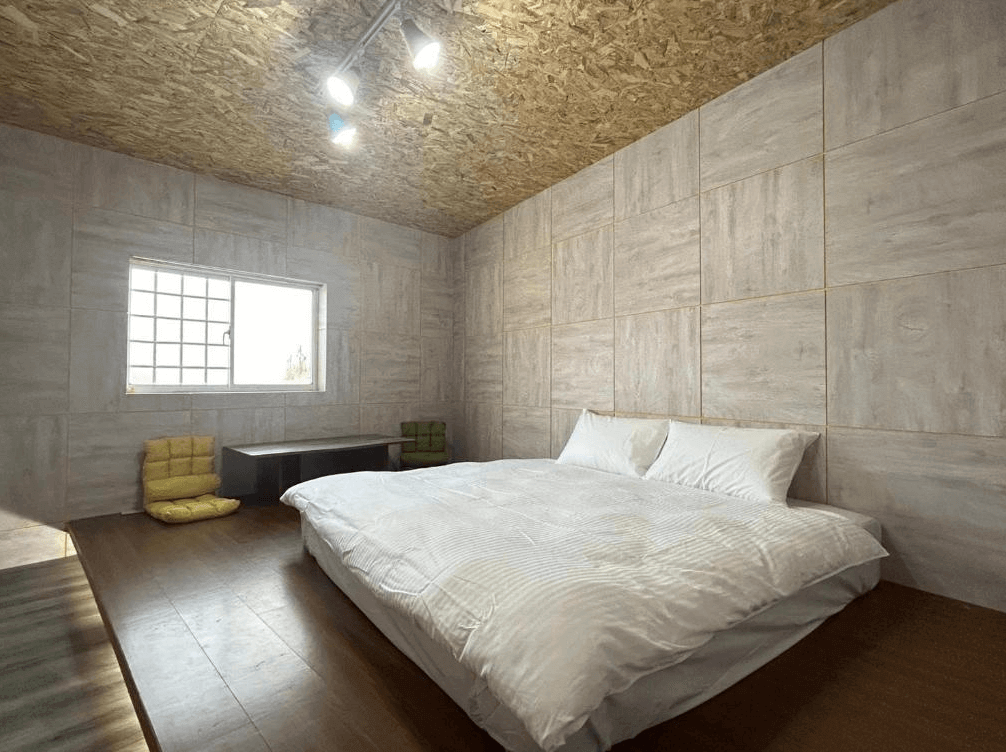 【蘭嶼住宿】蘭嶼．Hi海背包客棧日式客房：木質地板搭配低床設計，房內有落地窗與矮桌座墊，簡單清爽的風格。