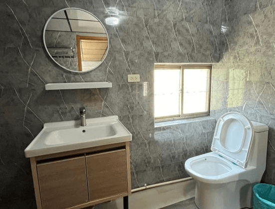 【蘭嶼住宿】蘭嶼．Hi海背包客棧衛浴空間：灰色大理石紋牆面，設有洗手台、大鏡子與馬桶，採光良好，乾淨明亮。