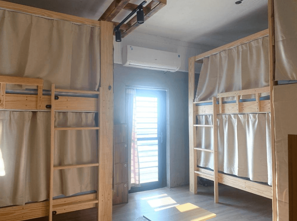 【蘭嶼住宿】那天 THat day Hostel 背包客房：木質上下舖設計，床位配有布簾保持隱私，房內採光良好並設有冷氣與置物櫃，氛圍簡約舒適。