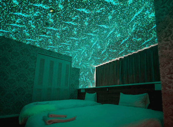 【名護住宿】里耶塔中山旅館 (Lieta Nakayama) 星空主題房，房內天花板點綴滿天星光效果，營造浪漫夢幻氛圍，配有兩張單人床。