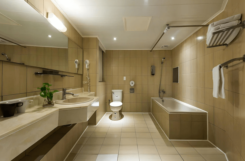 【板橋住宿】馥俐商旅 浴室空間，設有浴缸、淋浴與洗手台，整體以米色磁磚設計，乾淨寬敞。