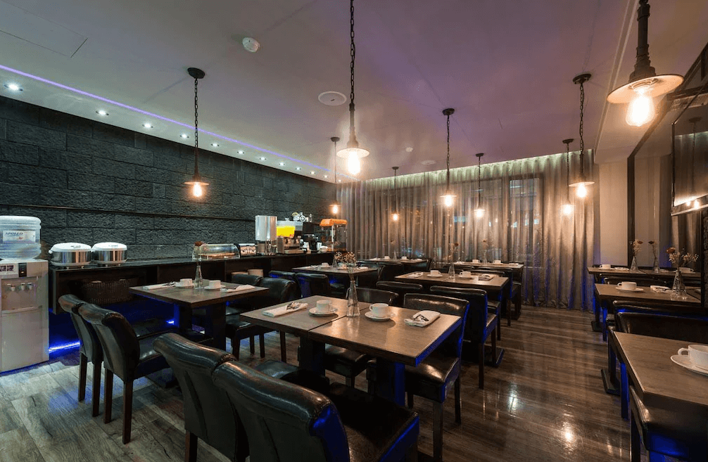 【板橋住宿】馥俐商旅 餐廳環境，黑色牆面搭配吊燈設計，桌椅排列整齊，提供旅客舒適的用餐氛圍。