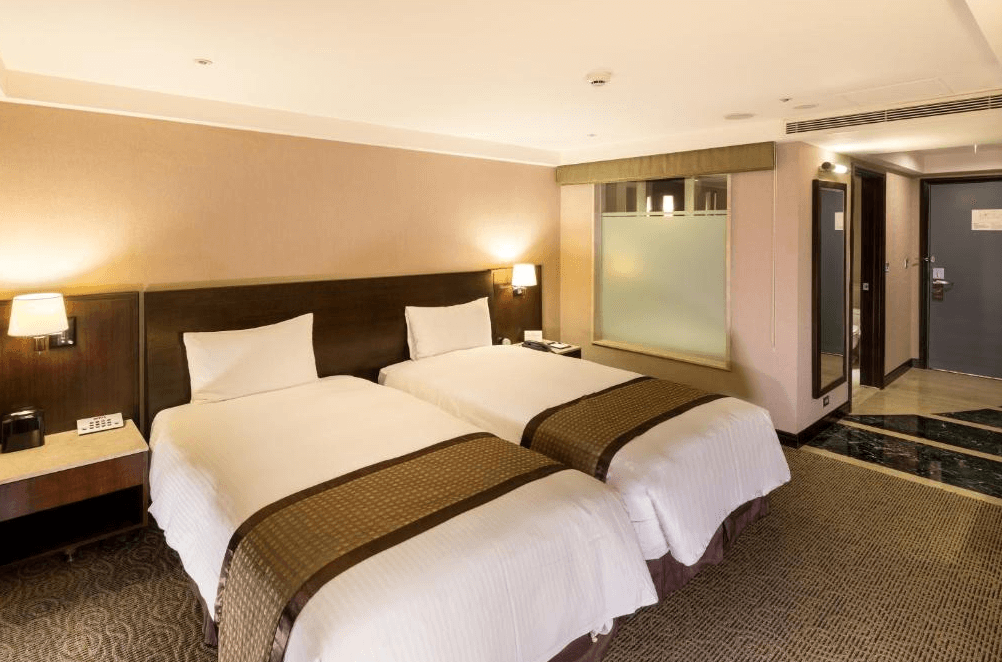 【板橋住宿】馥都飯店 標準雙床房，簡約典雅設計，床頭採用木質搭配柔和燈光，營造溫馨氛圍。