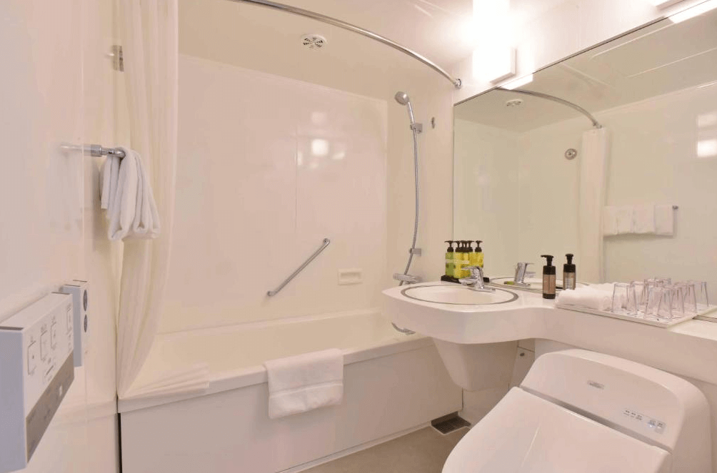 【旭川住宿】ART旭川酒店 (Art Hotel Asahikawa) 客房內浴室，白色乾淨設計，配有浴缸、淋浴設備、免治馬桶與洗手台，並提供齊全的盥洗備品。