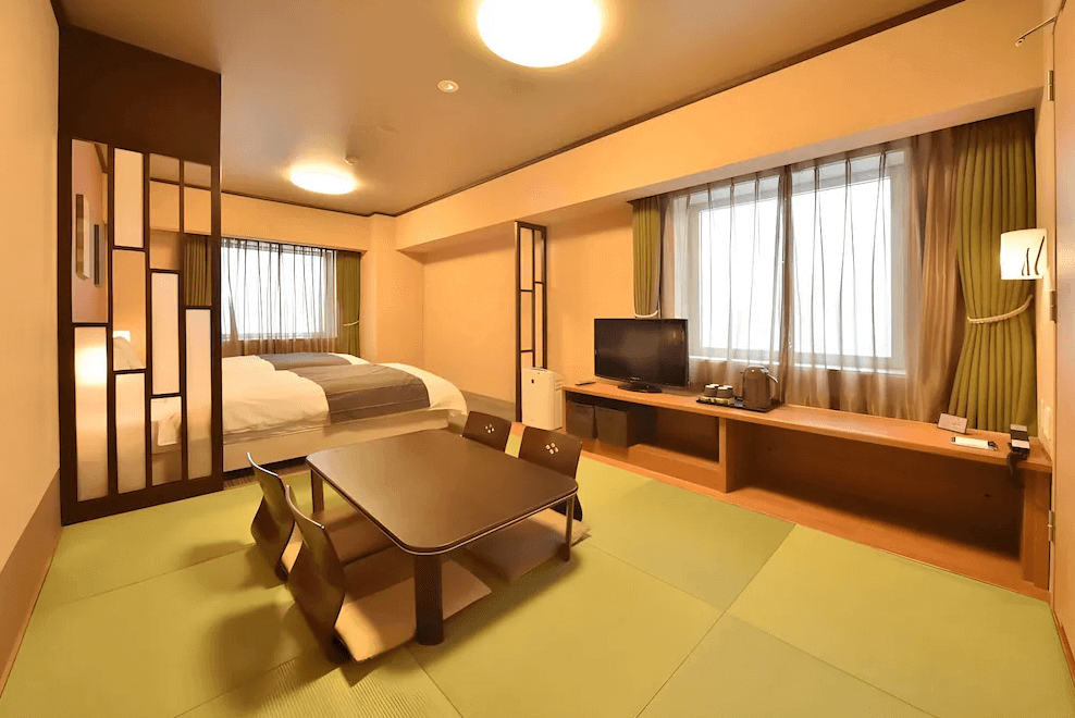 【旭川住宿】Dormy Inn飯店-旭川天然溫泉 (Dormy Inn Asahikawa Natural Hot Spring) 和洋式客房，設有榻榻米地板、低桌椅組與雙人床，融合日式傳統與現代舒適設計。