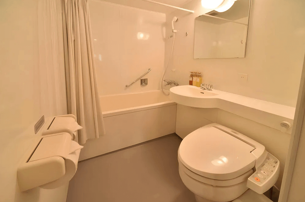 【旭川住宿】Dormy Inn飯店-旭川天然溫泉 (Dormy Inn Asahikawa Natural Hot Spring) 客房浴室，乾淨明亮的設計，配有浴缸、免治馬桶與齊全盥洗備品。