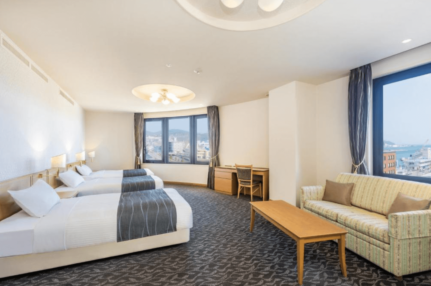 【小樽住宿】Nord小樽酒店 (Hotel Nord Otaru) 寬敞的三床客房，設有書桌與沙發休憩區，窗外可眺望山景與海景。