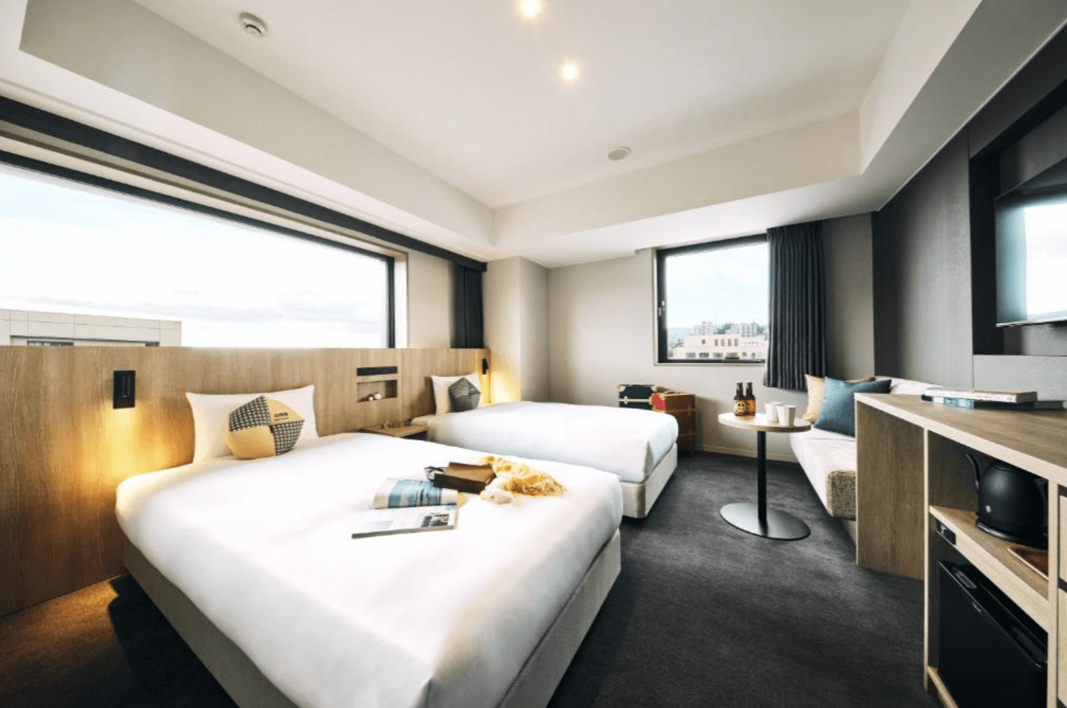 【小樽住宿】OMO5 Otaru by Hoshino Resorts 雙床房，大片窗戶採光明亮，可欣賞小樽市景與港灣，房內設計現代簡約。