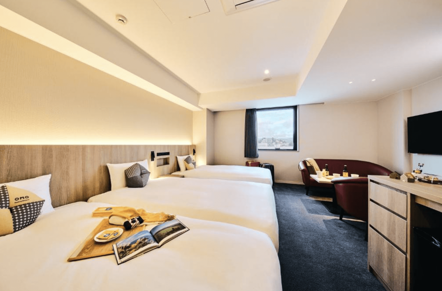 【小樽住宿】OMO5 Otaru by Hoshino Resorts 大床房，簡約灰白色調搭配木質家具，提供舒適沙發區與電視設備。