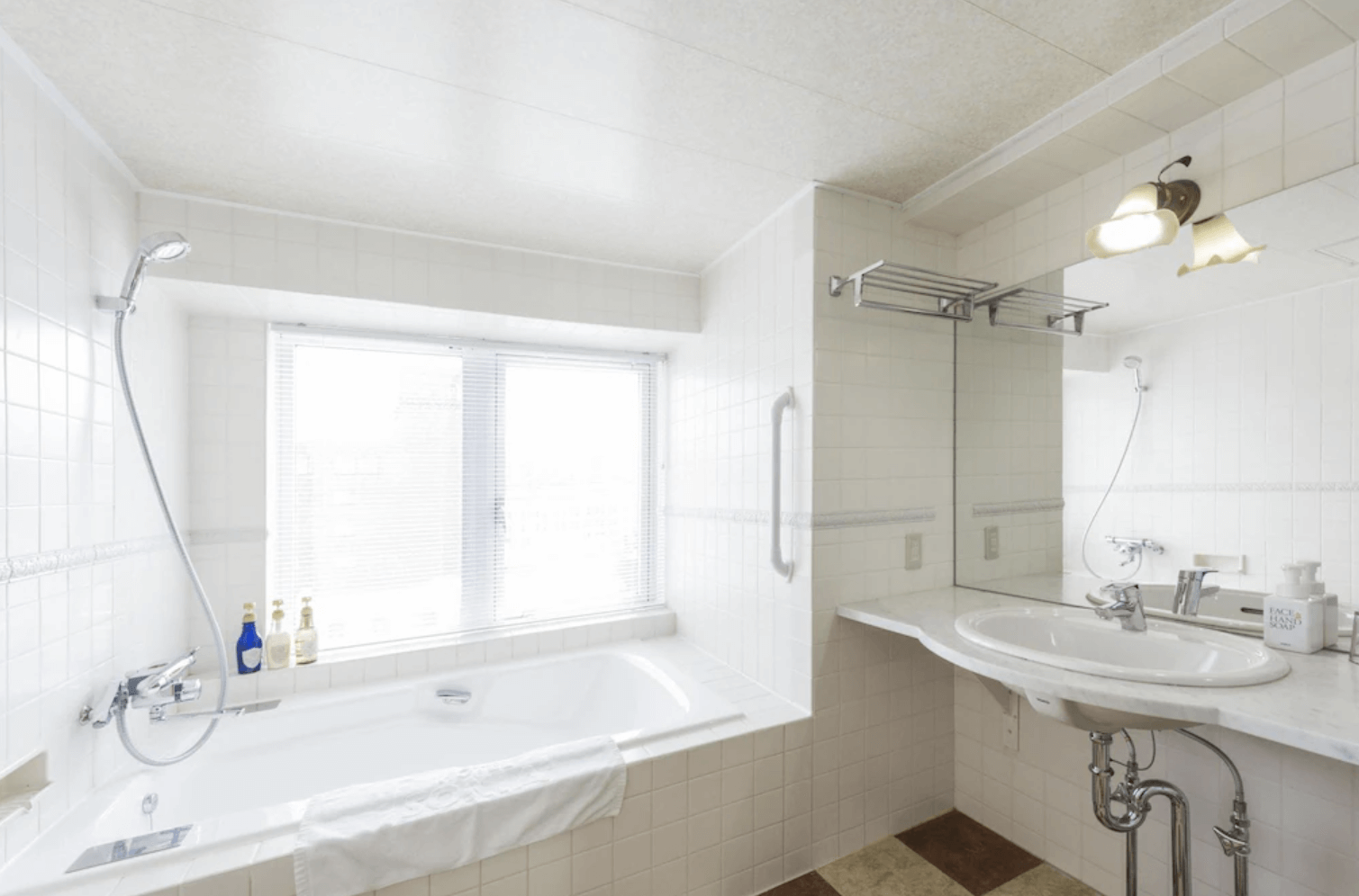 【小樽住宿】Sonia小樽酒店 (HOTEL SONIA Otaru) 明亮浴室，內有浴缸、淋浴與洗手台，窗邊採光良好，提供舒適洗浴空間。