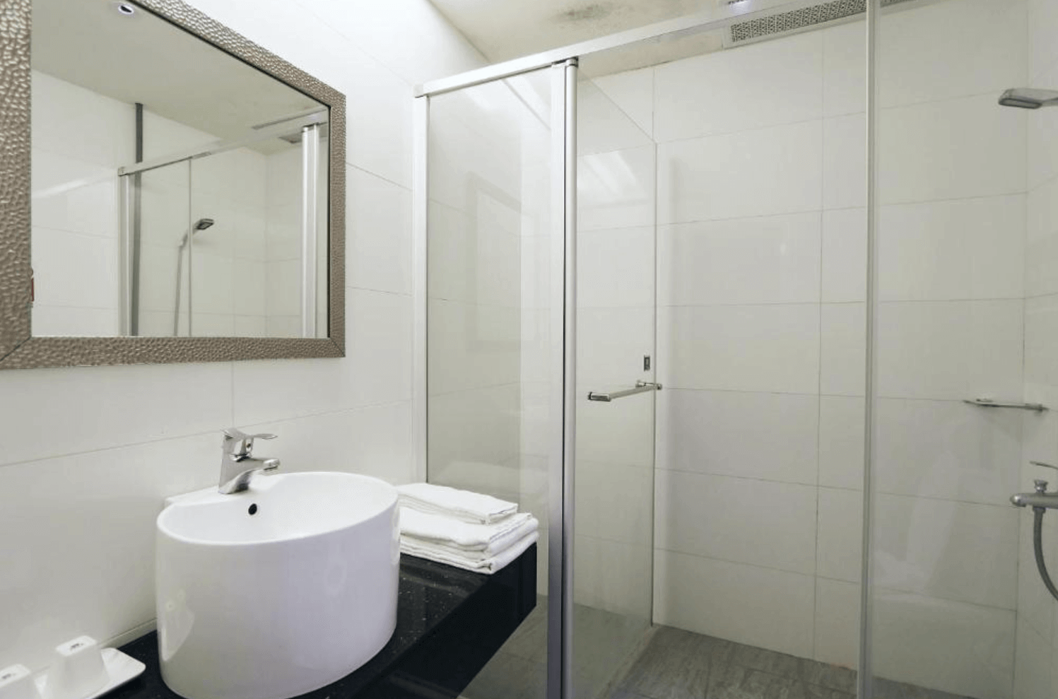 【前金住宿】兆舍行旅 浴室，設有乾濕分離淋浴間與白色洗手台，設計簡潔實用。