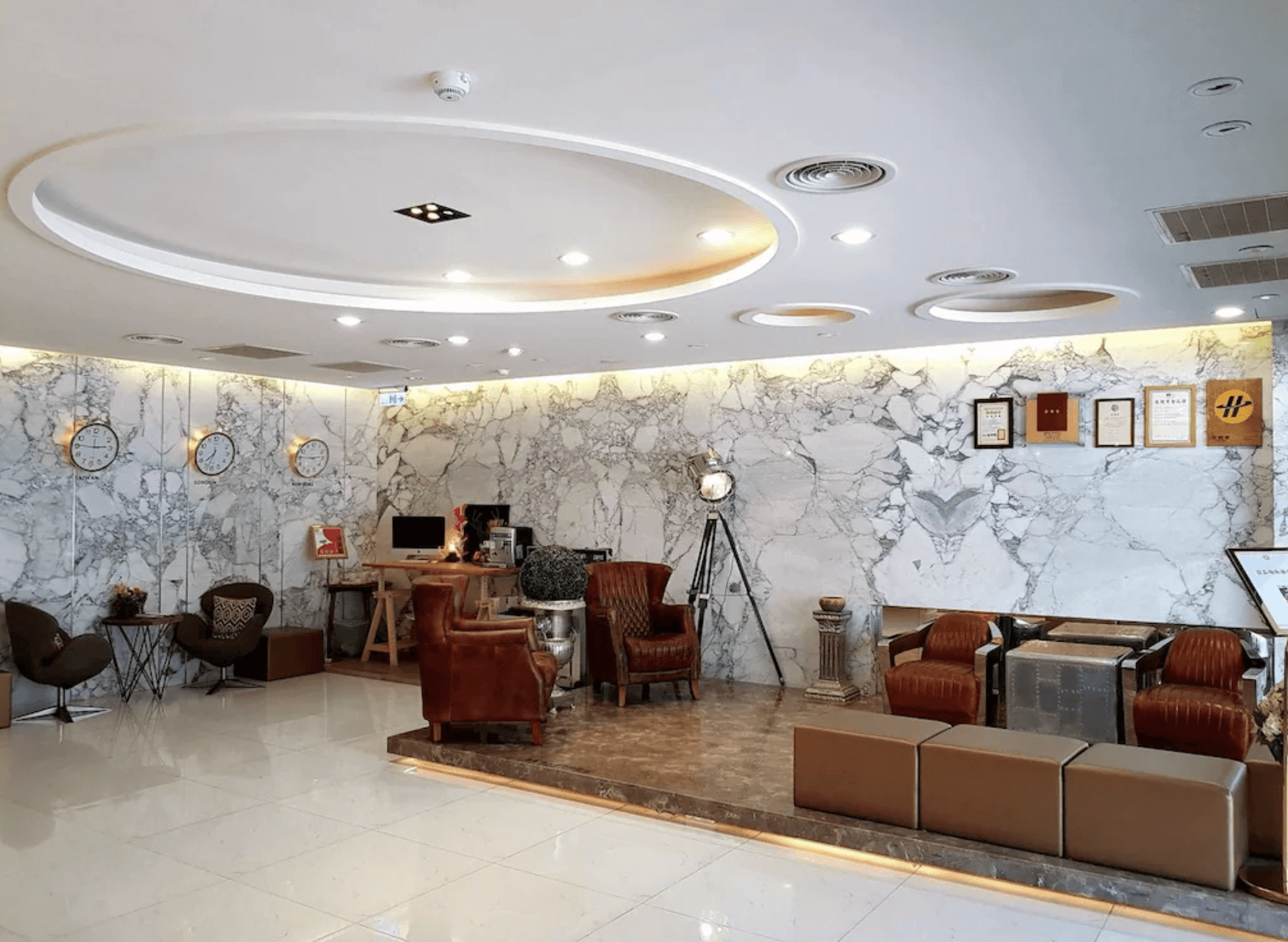 【前金住宿】兆舍行旅 大廳，採用大理石牆面設計，擺設皮革沙發與裝飾燈具，展現典雅氛圍。