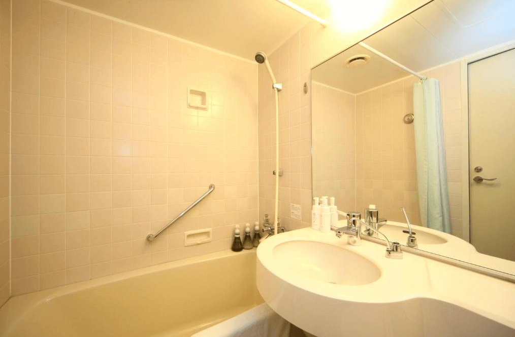 【函館住宿】函館國際酒店標準浴室，配備浴缸、淋浴、雙人洗手台與盥洗用品，簡潔實用。