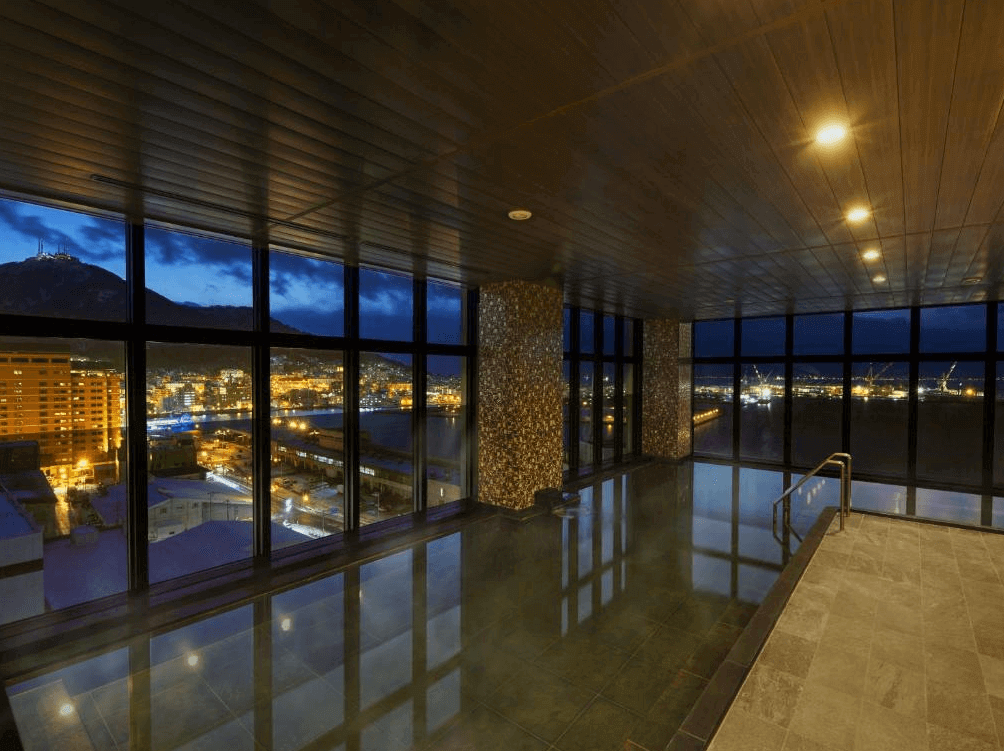 【函館住宿】函館國際酒店高樓層大浴場，寬敞玻璃窗可俯瞰函館夜景與港口景色，一邊泡湯一邊欣賞城市燈火。