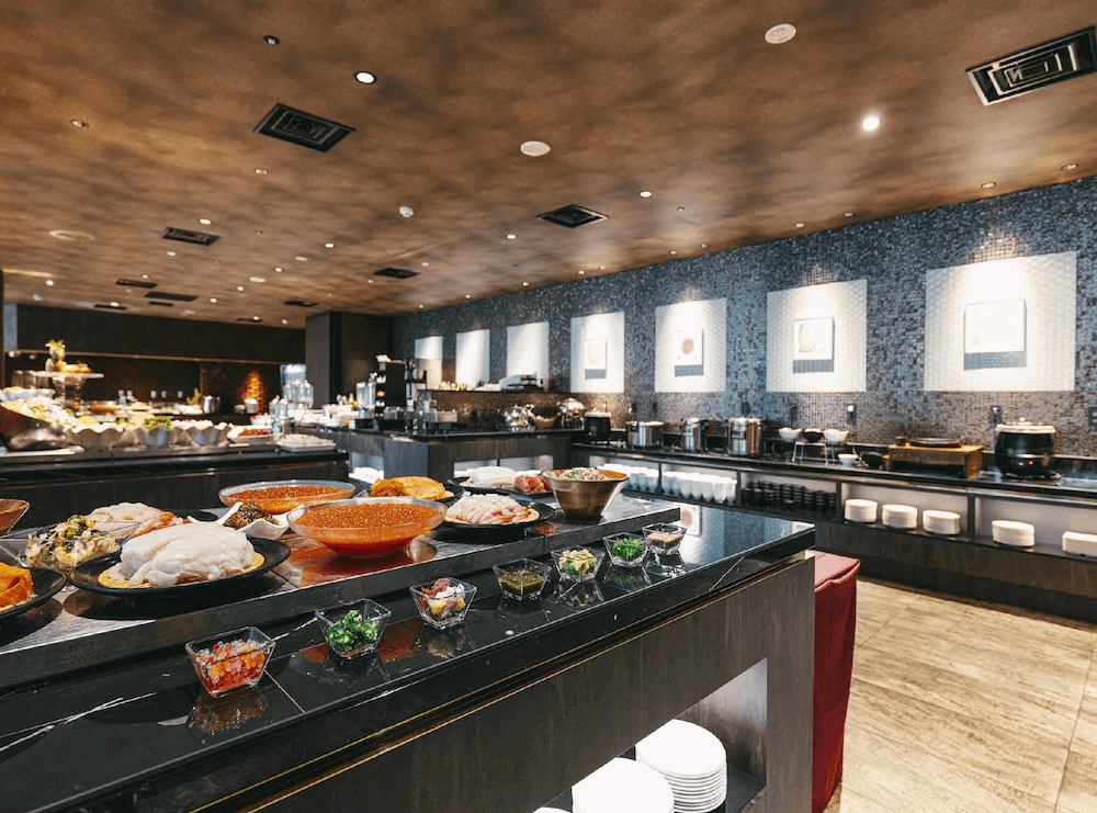 【函館住宿】函館國際酒店自助餐廳，餐檯上擺滿豐盛料理，包含新鮮海鮮與多樣熱食，提供旅客多元美食選擇。