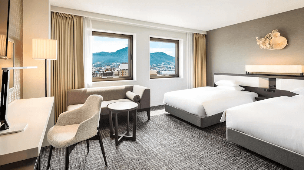 【函館住宿】函館普樂美雅凱賓總統酒店舒適雙床房，簡約明亮的設計搭配大窗戶，窗外能眺望函館山景與城市風光。