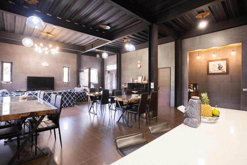 【玉里住宿】「吾笠塢民宿」公共交誼廳，挑高設計搭配現代吊燈，多組餐桌椅與沙發，適合團體聚會與用餐。