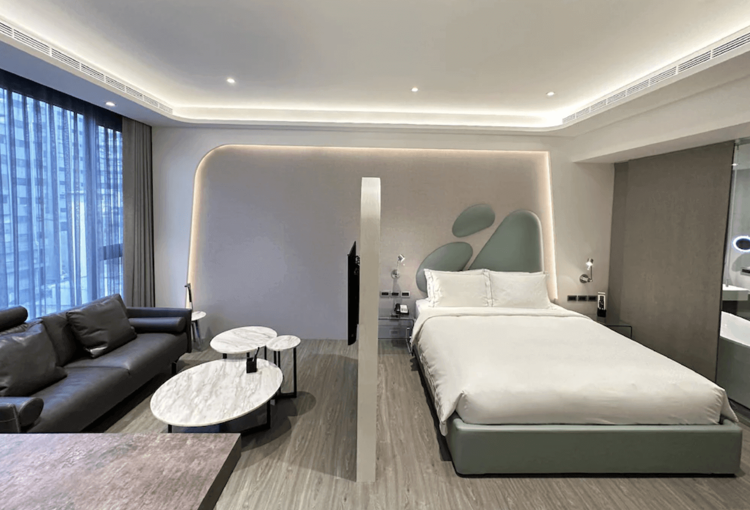 【前金住宿】高雄喜達絲飯店 — 現代客房：典雅簡約的大床房，設有沙發與大理石茶几，房內燈光柔和，設計感十足。