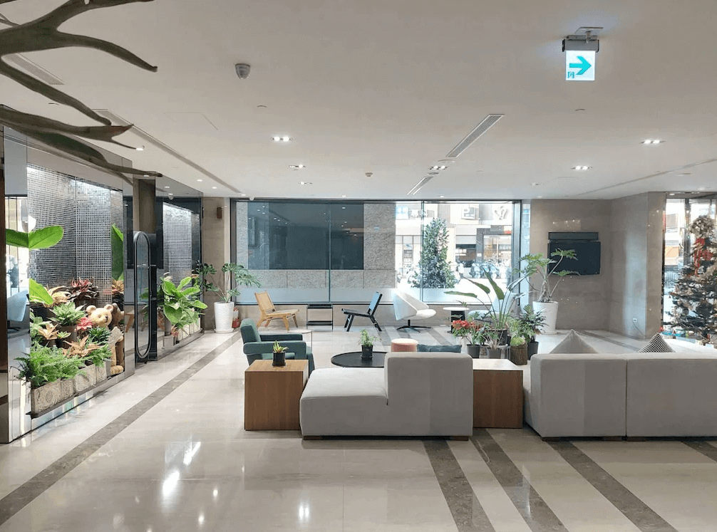 【高雄中央公園住宿】塔木德酒店高雄愛河館大廳：寬敞明亮的迎賓空間，綠植點綴與現代沙發座椅，打造舒適休憩氛圍