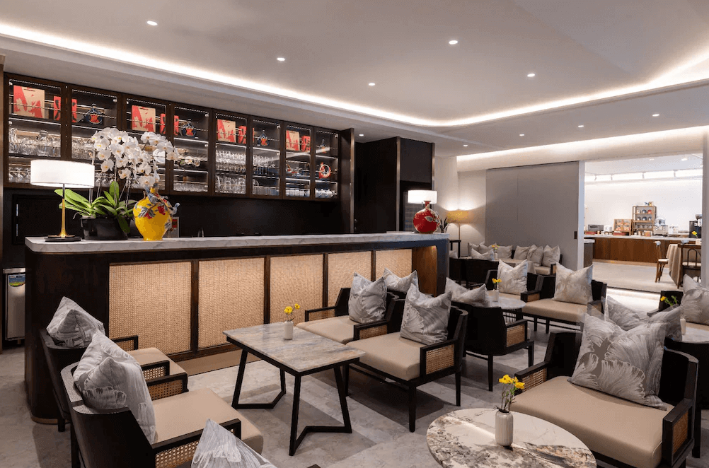 【高雄中央公園住宿】天成逸旅-舶寓高雄交誼廳：設有吧台與沙發座椅，溫暖燈光搭配木質與大理石材質，空間典雅舒適，適合旅客休憩或交流。