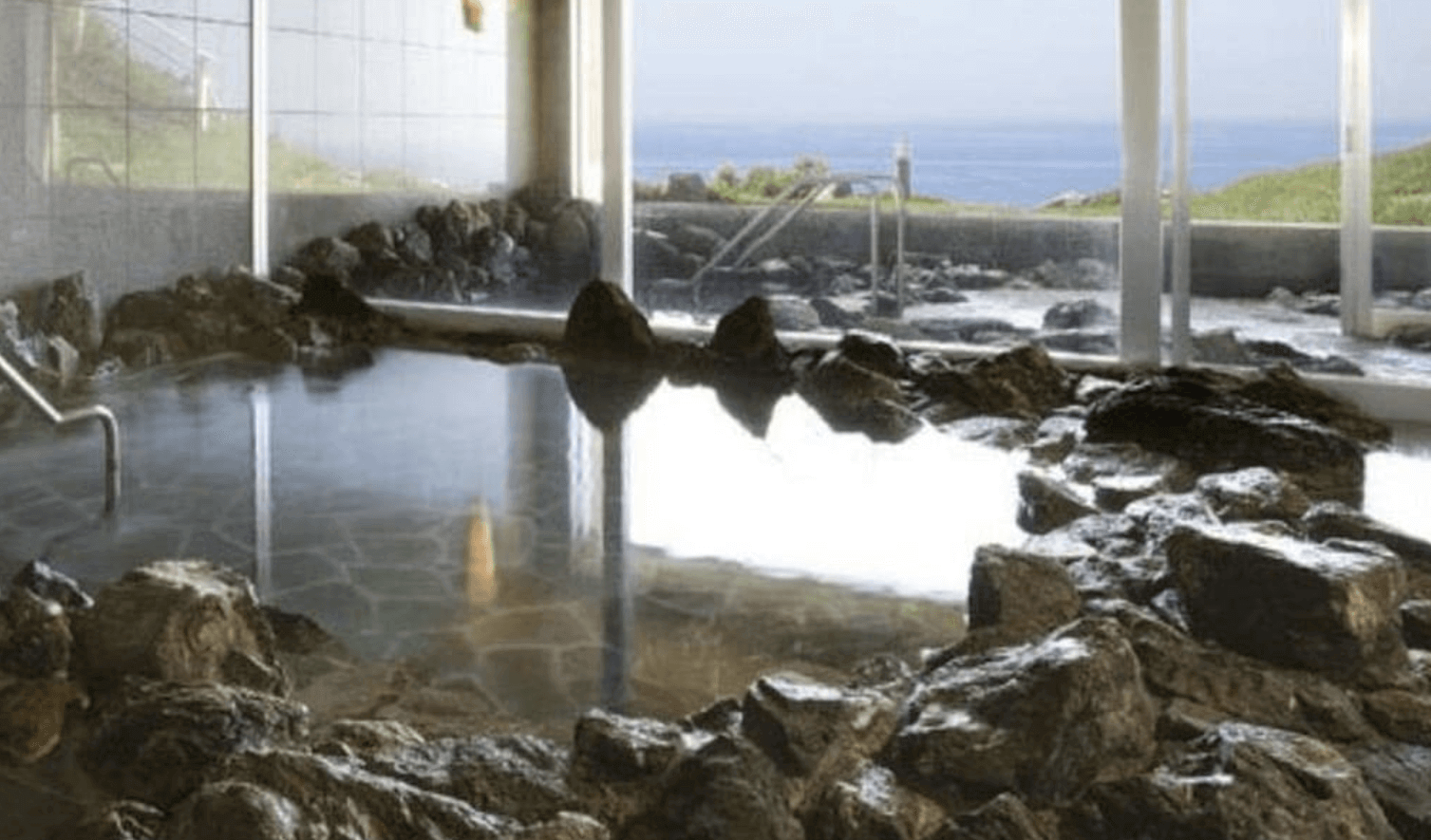 【小樽住宿】小樽城堡飯店 (Hotel Neuschloss Otaru) 岩石溫泉浴場，大片玻璃窗外是海天一線景觀，提供療癒泡湯體驗。