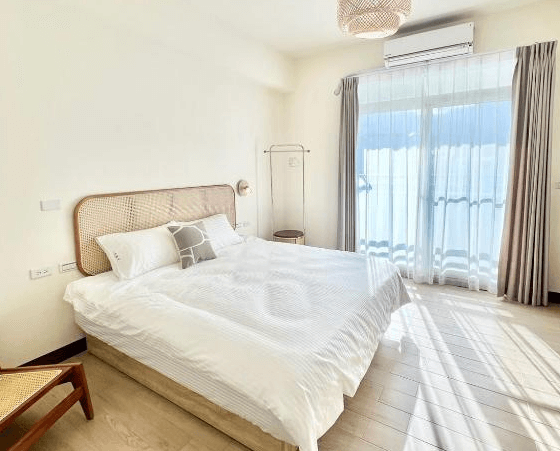 【玉里住宿】「小鳥散步玉里民宿」雙人房，設有大床與編織床頭板，落地窗引入自然光線，整體設計簡約溫馨。