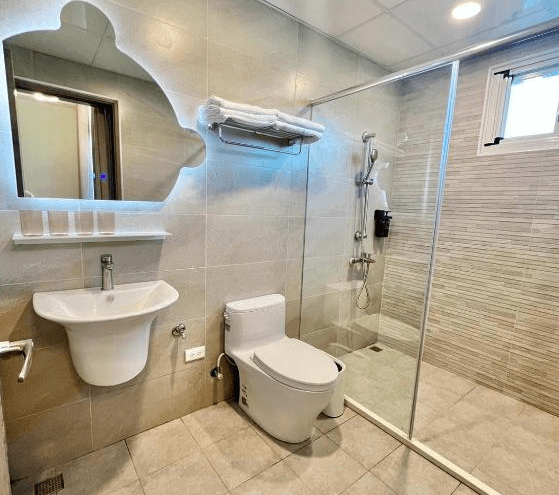 【玉里住宿】「小鳥散步玉里民宿」浴室空間，乾濕分離設計搭配玻璃拉門，米色磁磚牆面與特色造型鏡子，設備新穎整潔。