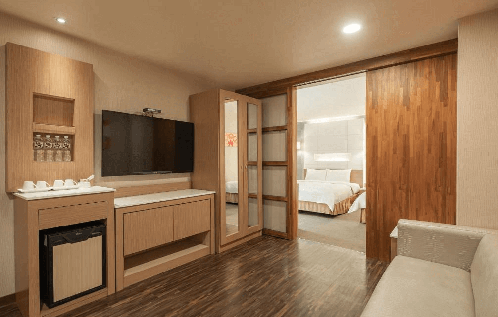 【三多商圈住宿】康橋商旅三多商圈館房內設施，設有液晶電視、冰箱、茶水備品與木質收納櫃，並可通往雙人房間。