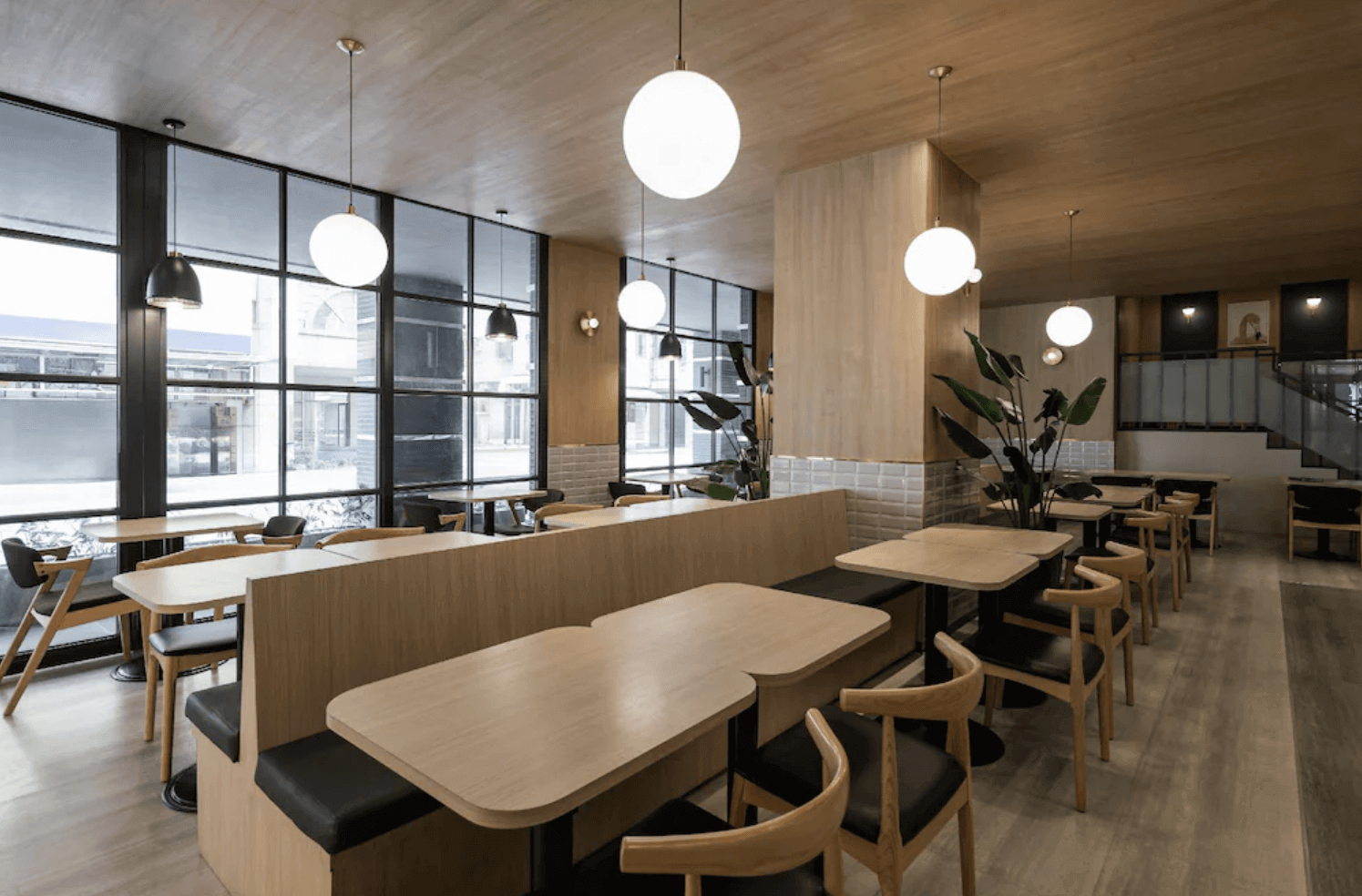 【前金住宿】康橋商旅 六合夜市中正館 餐廳空間，木質桌椅搭配大片玻璃窗與吊燈，環境明亮舒適，適合享用早餐。