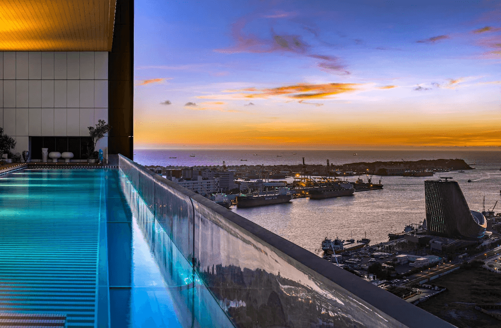 【三多商圈住宿】承億酒店 無邊際泳池：高樓層戶外泳池，夕陽映照港灣美景，遠眺高雄港與海景。