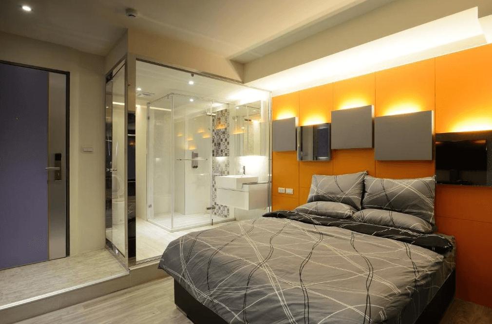 【三多商圈住宿】旅悅國際青年旅館雙人房，設有現代化淋浴間與玻璃隔間，搭配橘色與灰色設計牆面，營造年輕時尚氛圍。