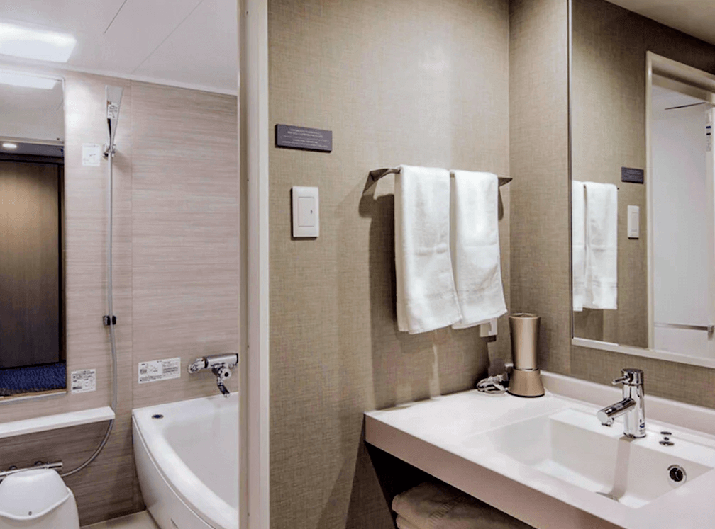 【旭川住宿】旭川JR飯店 (JR Inn Asahikawa) 客房浴室，乾濕分離設計，設有浴缸、淋浴設備與洗手台，提供齊全盥洗用品。