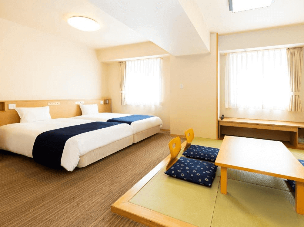 【旭川住宿】旭川WBF大飯店 (Hotel WBF Grande Asahikawa) 和洋式雙床房，設有兩張單人床與榻榻米區，搭配低桌與座墊，融合日式與現代舒適風格。