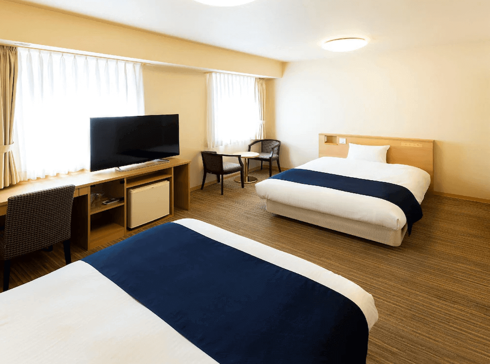 【旭川住宿】旭川WBF大飯店 (Hotel WBF Grande Asahikawa) 洋式家庭房，兩張大床搭配電視與書桌，窗戶採光良好，空間寬敞明亮。