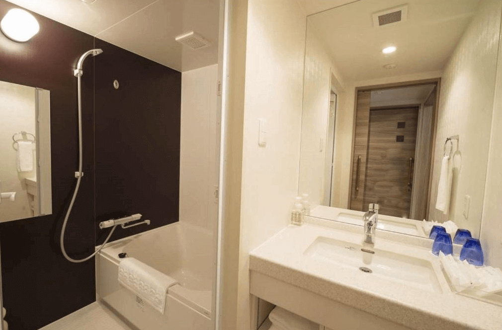 【旭川住宿】旭川WBF大飯店 (Hotel WBF Grande Asahikawa) 客房浴室，乾濕分離設計，配有浴缸、淋浴設備與洗手台，整體明亮乾淨。