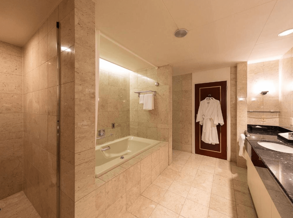 【札幌住宿】普樂美雅飯店 (Premier Hotel – TSUBAKI – Sapporo) 浴室空間，配置大型浴缸、獨立淋浴間與雙洗手台，採用米色大理石裝潢。
