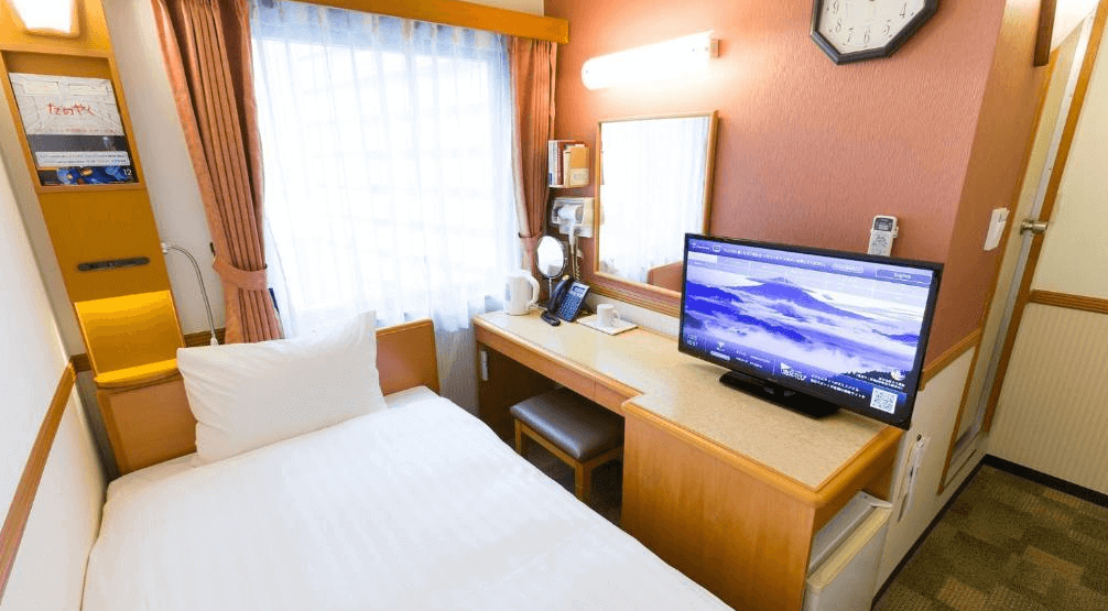 【函館住宿】東橫INN北海道函館站前朝市單人房，配置書桌、電視與大床，窗邊自然光充足，空間設計精巧。