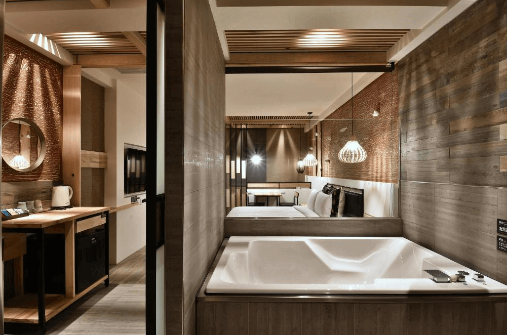 【鳳山住宿】歐閣精品汽車旅館-簡愛館浴室套房豪華浴室內設有大型浴缸與雙洗手台，黑白相間地磚營造高雅氛圍，浴缸內灑有玫瑰花瓣，增添浪漫感。