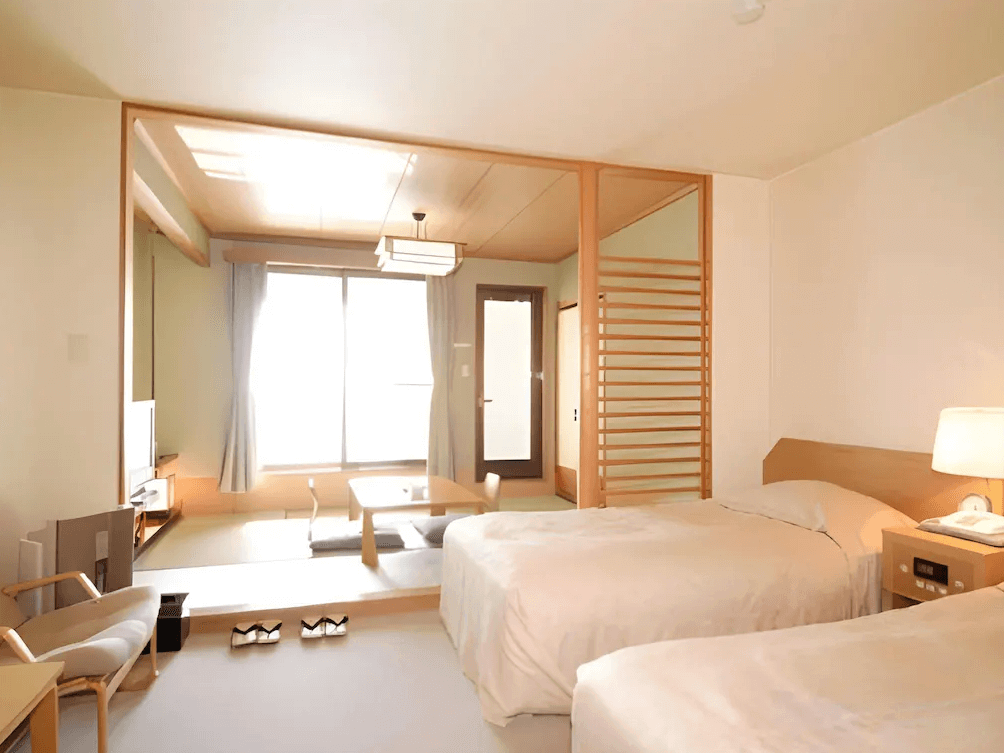【函館住宿】湯之川渚太子酒店和洋式客房，配置雙床與榻榻米休息區，明亮落地窗引入自然光，展現簡約日式氛圍。