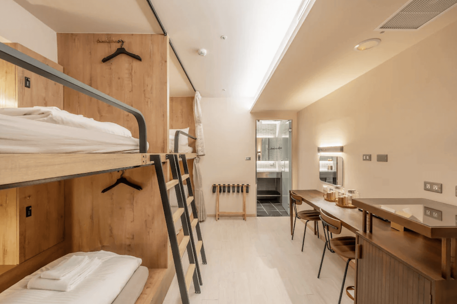 【前金住宿】高雄癮室 inns hotel — 四人上下舖房型：木質感十足的上下舖設計，搭配長桌與多張座椅，適合親子或團體入住，房內帶有獨立衛浴。