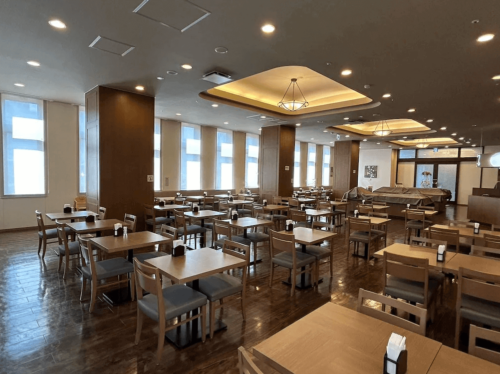 【函館住宿】露櫻GRANTIA函館站前店餐廳，木質桌椅與寬敞明亮的空間設計，提供旅客享用餐點的舒適環境。