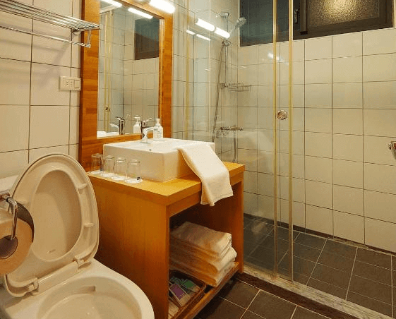 【赤柯山住宿】高寮貳陸之貳民宿浴室：乾濕分離的衛浴空間，設有洗手台、鏡子、馬桶與透明玻璃淋浴間，備有毛巾與盥洗用品。