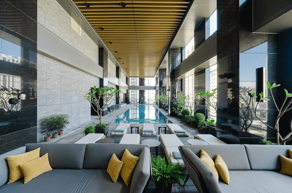 【三多商圈住宿】高雄日航酒店 室內泳池：現代化設計的泳池區，搭配綠植造景與休憩沙發，營造高雅悠閒的氛圍。