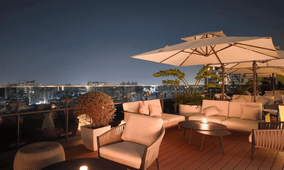 【三多商圈住宿】高雄日航酒店 空中露台酒吧：夜景下的戶外休憩空間，設有沙發座椅與大型遮陽傘，可欣賞城市夜景，氛圍浪漫迷人。