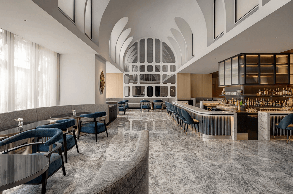 【三多商圈住宿】高雄洲際酒店大廳酒吧，挑高弧形天花板設計，搭配大理石地板與藍色絨布座椅，氛圍典雅現代，適合休憩與社交。