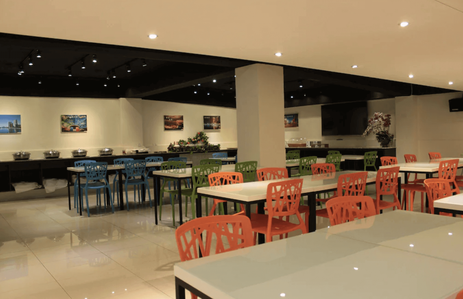 【前金住宿】高雄都會商旅 M-Hotel 餐廳，空間寬敞，搭配彩色餐椅與整齊的桌面，提供房客享用自助餐點。