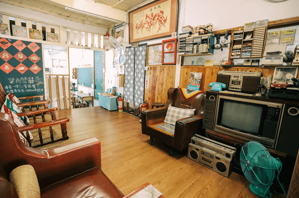 【鳳山住宿】鳳山79背包客黃埔青旅 懷舊交誼廳復古風格交誼廳，擺放木製沙發、老式電視與收音機，牆上貼有裝飾畫與卡帶架，充滿濃厚的懷舊氛圍。