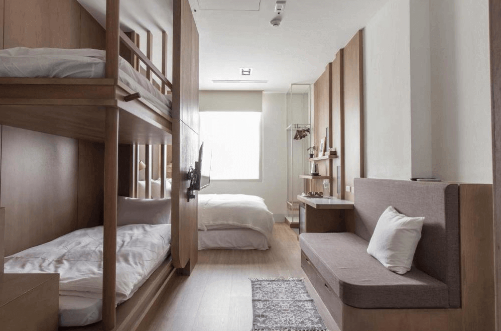 【高雄中央公園住宿】鶴宮寓家庭房：房內設有雙層床與大床，並配置沙發區，空間寬敞明亮，適合親子與多人入住。